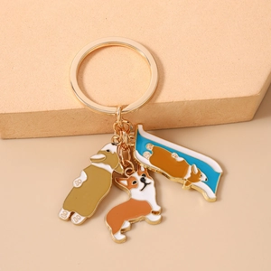 Detailed macro view of three Corgi enamel charms on a golden fashion metal keychain