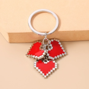 Detailed view of red pixel heart pendants on a silver keychain over a soft pink background