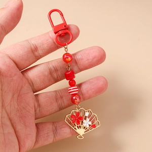 Détail d'un pendentif en forme d'éventail cerisier rouge avec porte-clés à perles