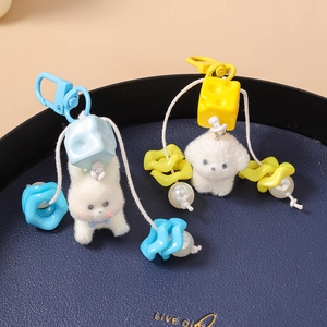 Detail of plush cat keychains in blue and yellow with colorful dice and pearl charms