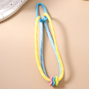 Détail de lanière tressée multicolore avec mousqueton bleu et breloques en plastique