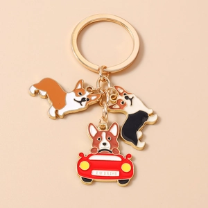 Detailed view of three cute Corgi charms on a gold keychain with enamel finish