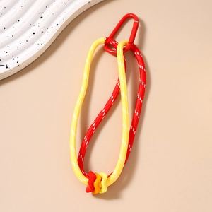 Détail macro du porte-clés en paracorde tressée rouge et jaune avec ornements ondulés