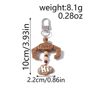 Detailed view of brown claw keychain with white and red beads and a blue star cloud charm