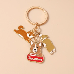 Detail view of golden keychain featuring cute Shiba Inu and Corgi enamel dog charms