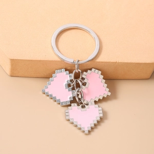 Detailed view of pink pixel art heart keychains on a beige geometric display stand