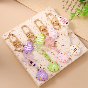 Cute cloud cookie keychains in purple, green, pink, and white with golden metal clasps