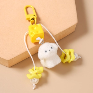 Detail of plush white puppy keychain with yellow cheese charm and decorative beads