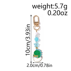 Détail du porte-clés dinosaure vert de 10cm avec perles bleues et fermoir homard