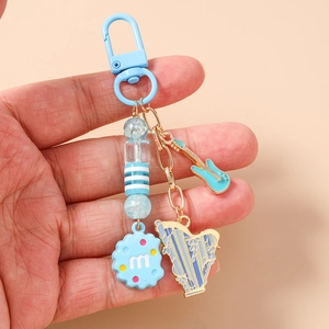 Detail of blue beaded keychain with electric guitar, harp charms and round 'm' pendant