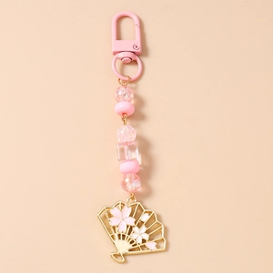 Détail du porte-clés perlé avec pendentif éventail rose et motifs de fleurs de cerisier