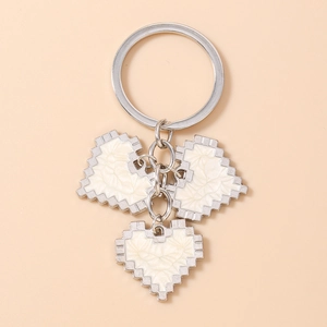 Macro shot of mosaic pixel heart keychain with three charms on a polished silver ring
