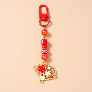 Détail du porte-clés à perles rouges avec pendentif éventail sakura et fermoir en métal doré