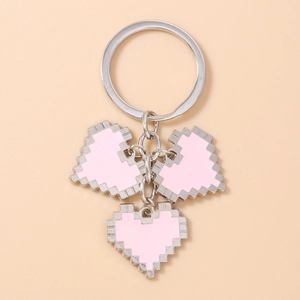 Detail of metal keychain with three pink pixel art heart charms on silver rings