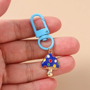 Detail of a blue spotted mushroom keychain with a light blue metal lobster clasp