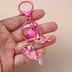 Detailansicht der rosa Delfin-Anhänger mit Pailletten und passendem Glocken-Schlüsselanhänger
