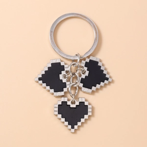 Macro detail of silver pixelated heart charms with black enamel on metal keychain