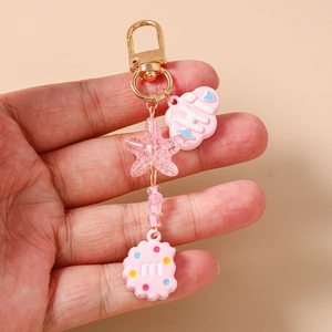 Pink heart-themed keychain with glitter star, cloud, and biscuit charms held in hand