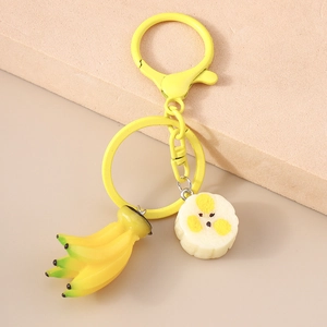 Detailed close-up of yellow banana keychain with realistic fruit texture and metal hook