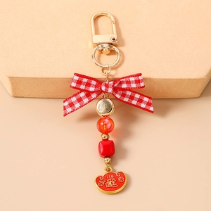 Detail view of a beaded keychain with lucky charm and bow for wealth and success