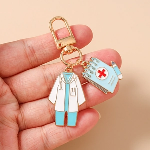Detail of medical keychain with nurse coat and blue clip chart held by hand