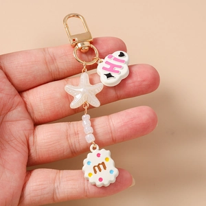 Detailed view of cloud and starfish keychain with beaded chain and cookie letter charm