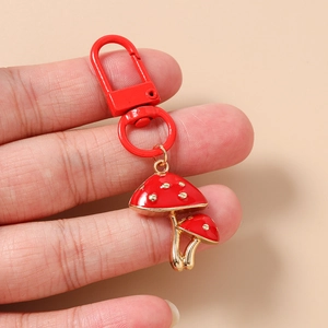 Detail of red mushroom keychain with gold polka dots and a red metal lobster clasp