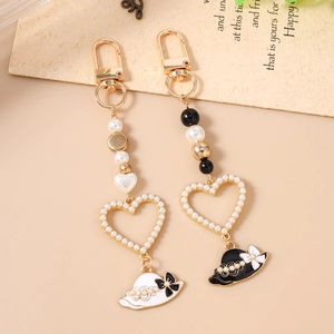Elegant beaded heart and straw hat charms on gold-tone keychain for handbags