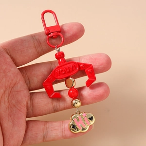 Detail of red claw keychain with golden cloud pendant and beaded lobster clasp strap