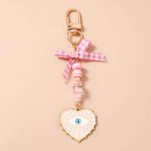 Detail of pink evil eye heart keychain with beads and a stylish plaid ribbon bow