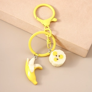 Detailed close-up of yellow banana charms and lobster clasp on a stone surface