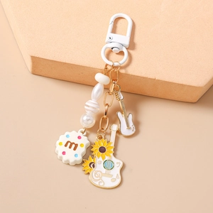 Close-up of guitar and cookie charms with beads on a keychain with lobster clasp