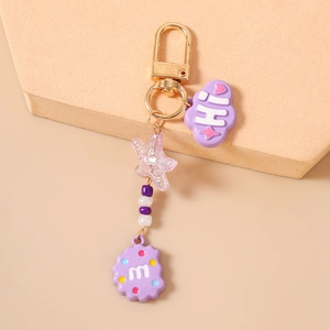 Detail of beaded starfish keychain with purple clouds and alphabet charms on gold D-ring
