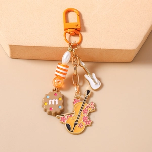 Detail of beaded keychain with guitar, cello, and cookie pendants on a display