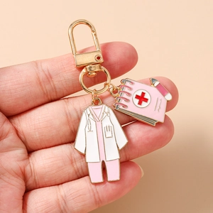 Detailed enamel keychain featuring a white medical coat and pink notebook medical charms