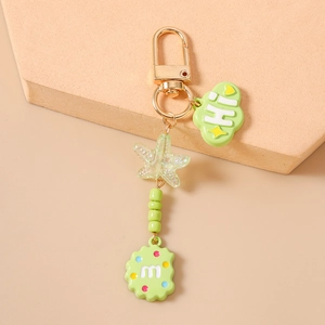 Detail of beaded starfish keychain with green cloud Hi charm and m biscuit pendant