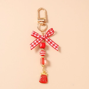 Detailed close-up of a red beaded keychain with gold D-ring, bow, and enamel lucky bag charm