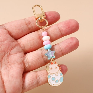 Détail du porte-clés dinosaure avec perles macaron et fermoir doré métallisé