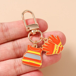 Detail of firefighter keychain with orange safety vest and gloves enamel charms