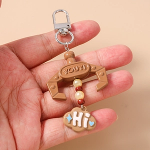 Detail of mechanical claw keychain with beaded accents and blue heart cloud charm
