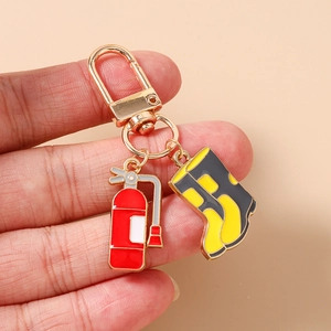 Detail showing a fire extinguisher and yellow firefighter boot alloy keychain charms