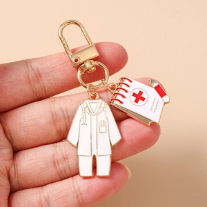 Detailed close-up of a medical keychain featuring gold alloy nurse scrubs and notepad charms