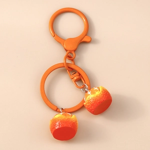 Detail of orange fruit keychain with textured peels and matching matte orange hardware