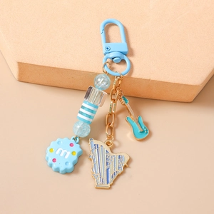 Detail view of light blue guitar and harp music charms with beaded keychain accents