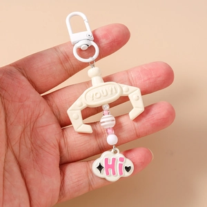 Detail of beaded claw machine keychain with pink clouds and white metal D-ring hook