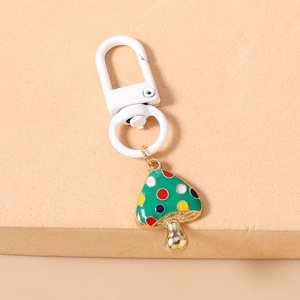 Macro shot of creative green mushroom keychain with colorful dots and white lobster clasp