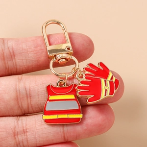 Detail view of firefighter safety vest and glove keychain charm set with golden lobster clasp