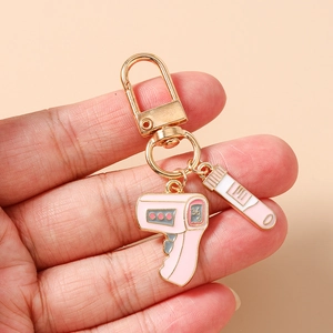 Detail of medical keychain with pink enamel thermometer and test tube charms