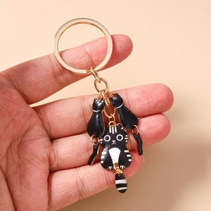 Détail d'un porte-clés doré avec d'un chat mignon avec des pendentifs et une queue mobile