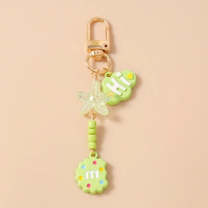 Detail view of green beaded starfish keychain with cloud and alphabet cookie pendants